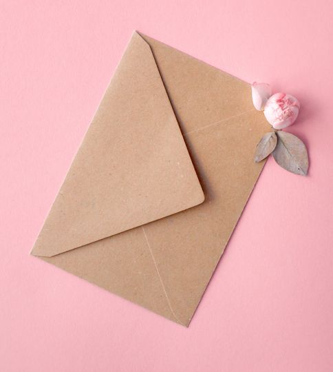 Pink roses on an envelope from kraft paper on a pale pink background